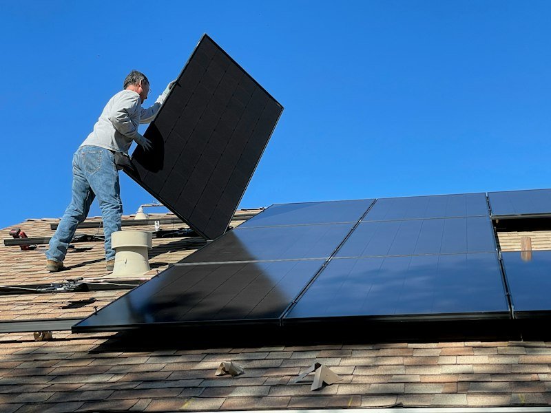 Technician installing rooftop solar panels